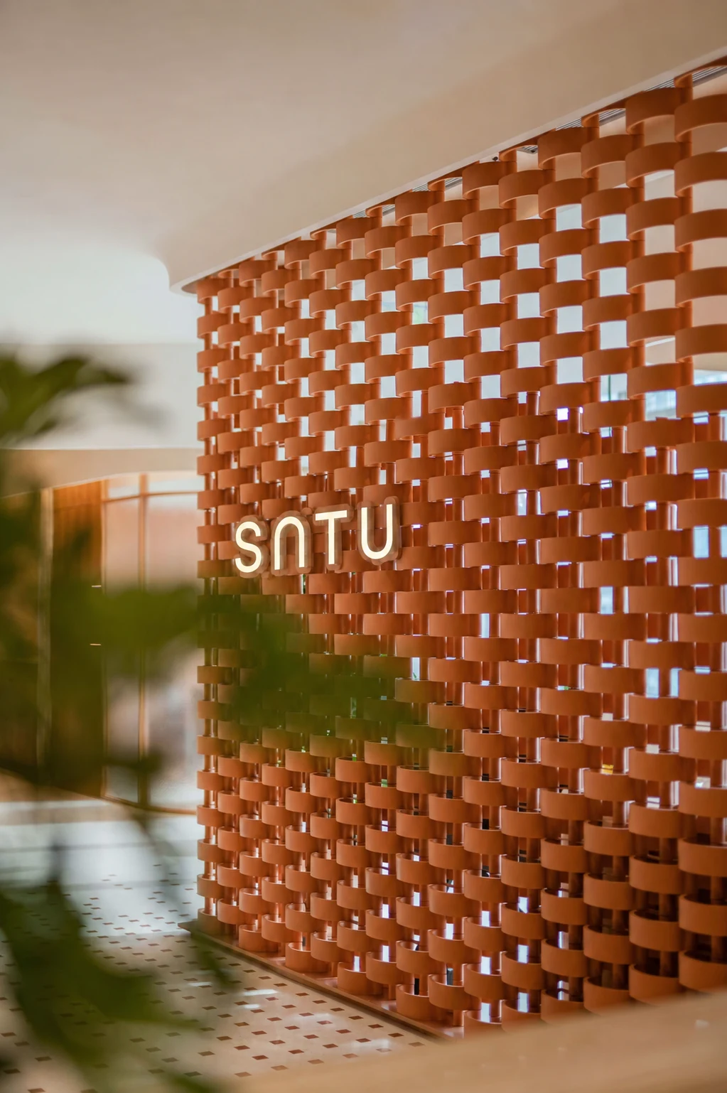 SATU identity on a sculptural terracotta screen